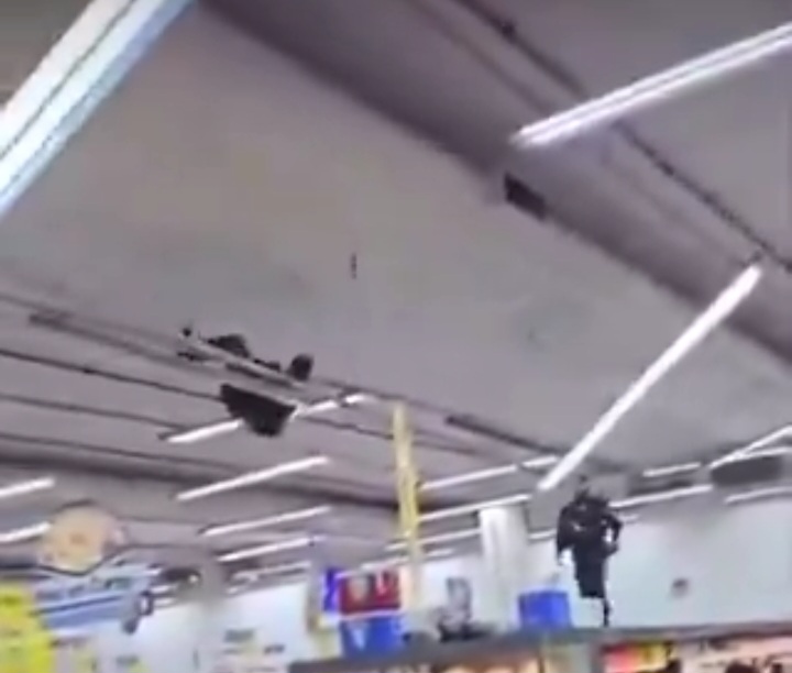 Homem se pendura no teto de supermercado e é retirado por policial